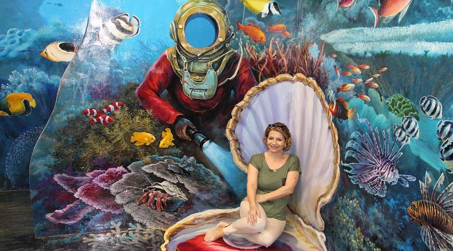 Visitor interacting with a 3D art installation at Art in Paradise Pattaya, creating an immersive optical illusion.